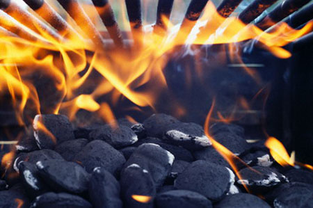Charcoal Briquettes Burning Below Grill --- Image by © Tim McGuire/CORBIS